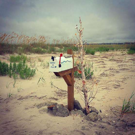 a mailbox on a beach with the flag in the up position