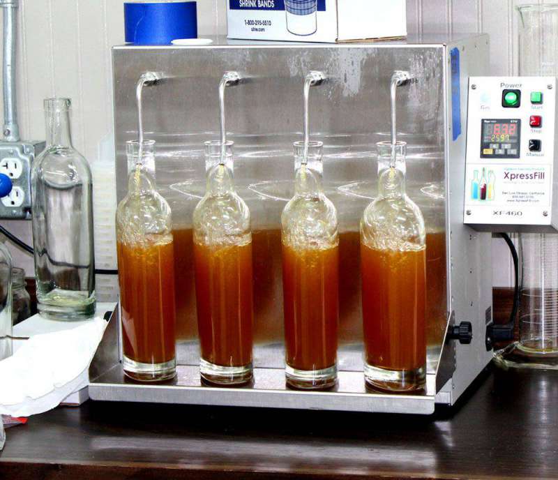 Whiskey bottles being filled by a machine